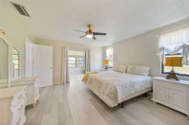 16615 Acapulco Rd, Punta Gorda, FL 33955 - bedroom featuring light wood-style floors, a textured ceiling, a ceiling fan, and baseboards