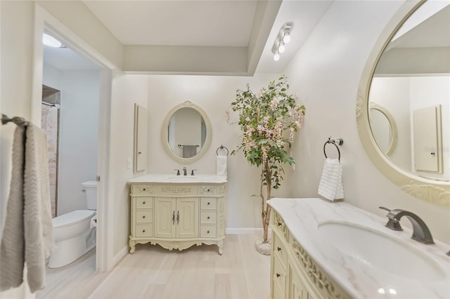 16615 Acapulco Rd, Punta Gorda, FL 33955 - full bathroom featuring toilet, two vanities, baseboards, and wood finished floors