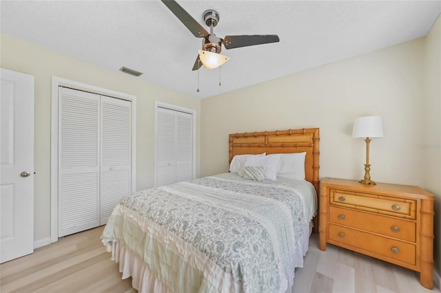 16615 Acapulco Rd, Punta Gorda, FL 33955 - bedroom featuring light wood finished floors, multiple closets, a ceiling fan, and a textured ceiling