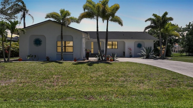 16615 Acapulco Rd, Punta Gorda, FL 33955 - ranch-style home featuring stucco siding, a front yard, and concrete driveway