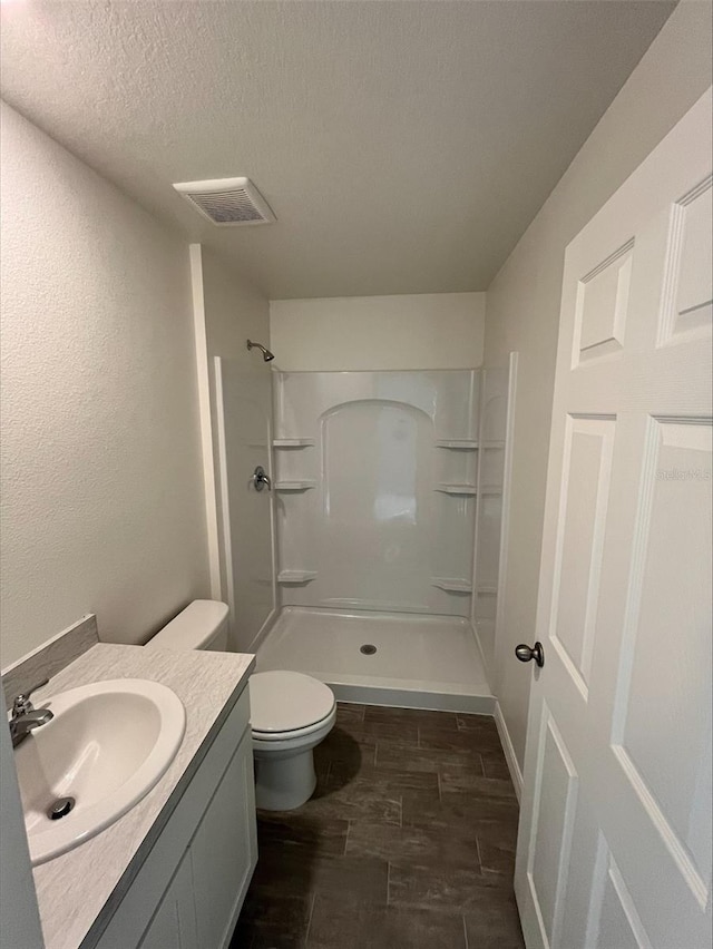 4200 Wanda St, Hastings, FL 32145 - bathroom featuring a walk in shower, toilet, a textured ceiling, vanity, and wood finished floors