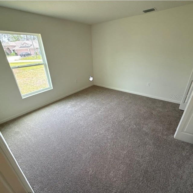 empty room with carpet and baseboards