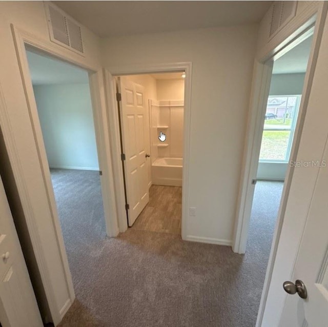 corridor with carpet and baseboards