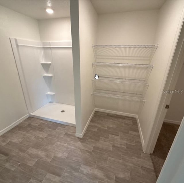 bathroom featuring baseboards and walk in shower