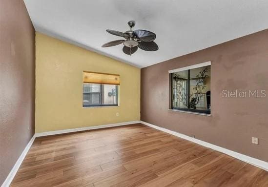 5046 San Rocco Ct, Punta Gorda, FL 33950 - unfurnished room with healthy amount of natural light, a ceiling fan, lofted ceiling, wood finished floors, and baseboards