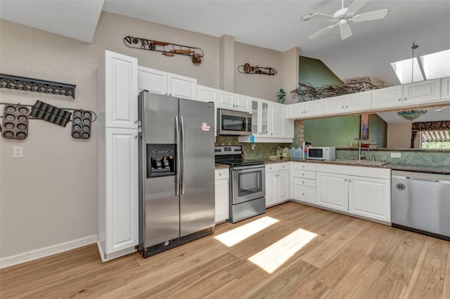 5046 San Rocco Ct, Punta Gorda, FL 33950 - kitchen with stainless steel appliances, a sink, decorative backsplash, light wood finished floors, and high vaulted ceiling