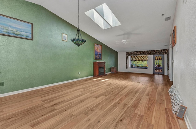 5046 San Rocco Ct, Punta Gorda, FL 33950 - unfurnished living room featuring a skylight, a textured wall, light wood-type flooring, a ceiling fan, and high vaulted ceiling