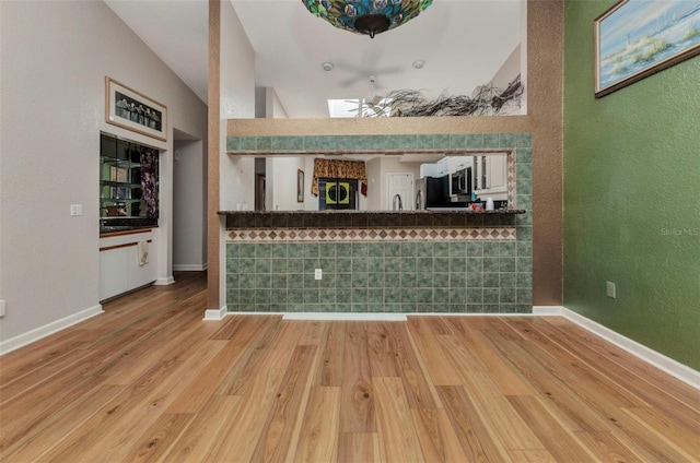 5046 San Rocco Ct, Punta Gorda, FL 33950 - bar area with wood finished floors, a textured wall, baseboards, stainless steel microwave, and refrigerator