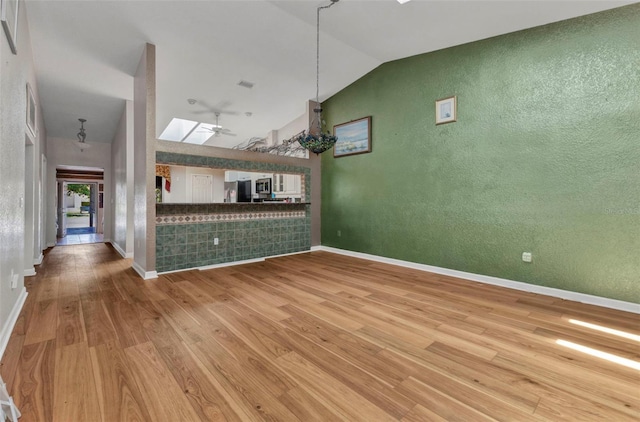 5046 San Rocco Ct, Punta Gorda, FL 33950 - unfurnished living room with wood finished floors, baseboards, and high vaulted ceiling