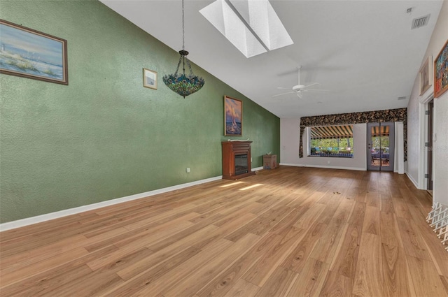 5046 San Rocco Ct, Punta Gorda, FL 33950 - unfurnished living room with a skylight, a ceiling fan, high vaulted ceiling, light wood-style flooring, and baseboards