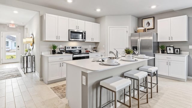 4967 Tuscola Blvd, North Port, FL 34287 - kitchen with stainless steel appliances, a sink, a breakfast bar area, white cabinetry, and recessed lighting