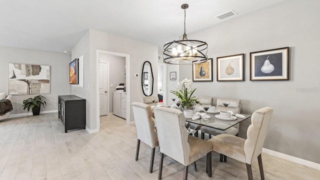 4967 Tuscola Blvd, North Port, FL 34287 - dining room featuring washing machine and dryer, a chandelier, light wood-type flooring, and baseboards