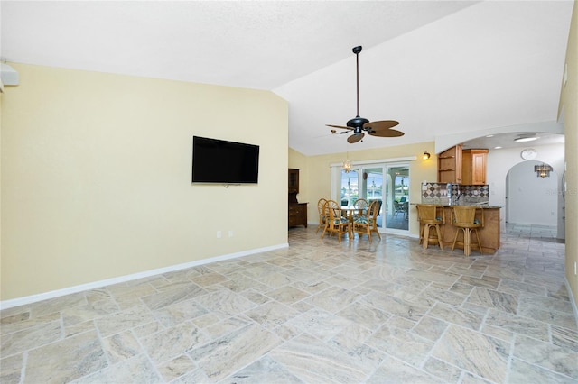 211 E Tarpon Blvd NW, Port Charlotte, FL 33952 - living area with light stone finish flooring, arched walkways, a ceiling fan, baseboards, and high vaulted ceiling