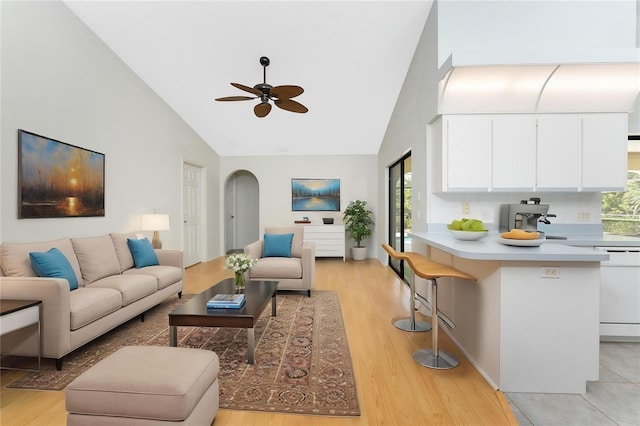 18111 Lake Worth Blvd, Port Charlotte, FL 33948 - living room featuring high vaulted ceiling, a ceiling fan, arched walkways, and light wood finished floors