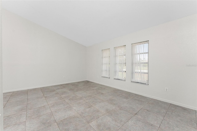 18111 Lake Worth Blvd, Port Charlotte, FL 33948 - empty room with vaulted ceiling, light tile patterned flooring, and baseboards