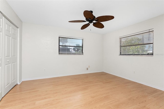 18111 Lake Worth Blvd, Port Charlotte, FL 33948 - unfurnished bedroom featuring light wood-type flooring, multiple windows, a closet, and ceiling fan