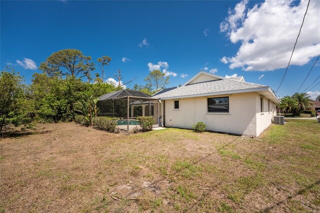18111 Lake Worth Blvd, Port Charlotte, FL 33948 - back of property featuring central air condition unit, a yard, stucco siding, and a lanai