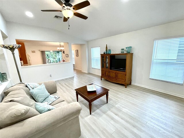 13170 SW Pembroke Cir N, Lake Suzy, FL 34269 - living room featuring a chandelier, vaulted ceiling, a ceiling fan, healthy amount of natural light, and light wood-style floors