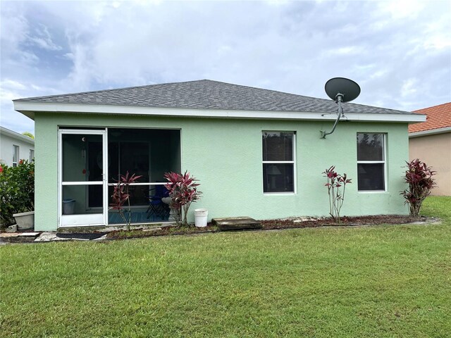 13170 SW Pembroke Cir N, Lake Suzy, FL 34269 - rear view of property with a lawn, a shingled roof, and a sunroom