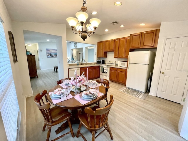 13170 SW Pembroke Cir N, Lake Suzy, FL 34269 - dining area with a chandelier, light wood-style floors, recessed lighting, healthy amount of natural light, and baseboards