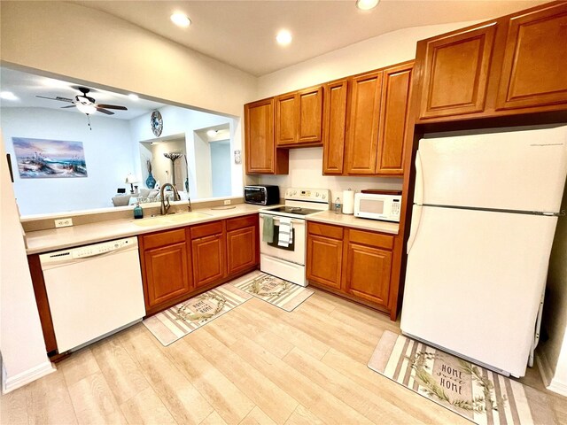 13170 SW Pembroke Cir N, Lake Suzy, FL 34269 - kitchen with white appliances, a sink, brown cabinetry, light wood-style floors, and light countertops