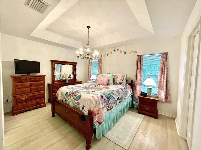 13170 SW Pembroke Cir N, Lake Suzy, FL 34269 - bedroom featuring a raised ceiling, hardwood / wood-style flooring, a chandelier, and baseboards