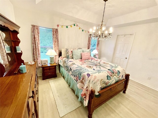 13170 SW Pembroke Cir N, Lake Suzy, FL 34269 - bedroom featuring light wood-type flooring, a chandelier, and baseboards