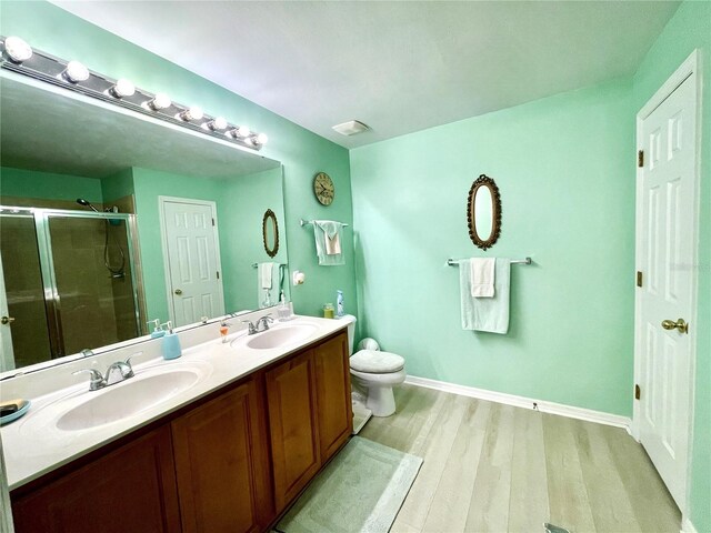 13170 SW Pembroke Cir N, Lake Suzy, FL 34269 - full bathroom featuring wood finished floors, double vanity, a stall shower, toilet, and baseboards