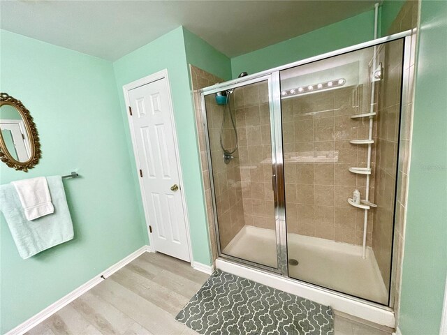 13170 SW Pembroke Cir N, Lake Suzy, FL 34269 - full bath featuring wood finished floors, a shower stall, and baseboards