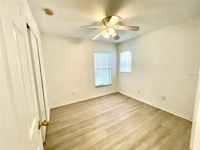 13170 SW Pembroke Cir N, Lake Suzy, FL 34269 - unfurnished bedroom with wood finished floors, baseboards, ceiling fan, and a closet
