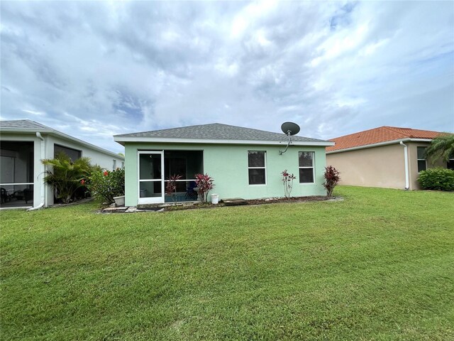 13170 SW Pembroke Cir N, Lake Suzy, FL 34269 - rear view of house with a sunroom, a yard, and stucco siding