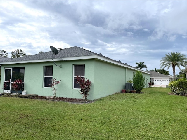 13170 SW Pembroke Cir N, Lake Suzy, FL 34269 - view of property exterior featuring stucco siding, a lawn, a shingled roof, and central AC unit