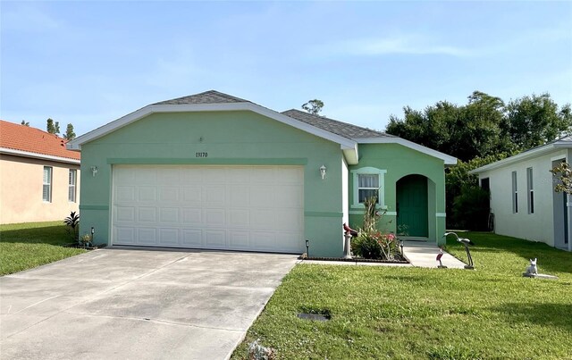 13170 SW Pembroke Cir N, Lake Suzy, FL 34269 - ranch-style house with a front lawn, a garage, concrete driveway, roof with shingles, and stucco siding