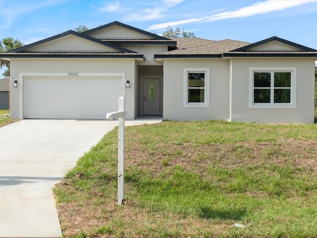 single story home featuring driveway, a garage, stucco siding, and a front yard