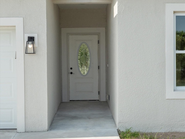 doorway to property featuring stucco siding