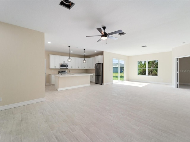 unfurnished living room with baseboards, light wood-type flooring, a sink, a ceiling fan, and recessed lighting
