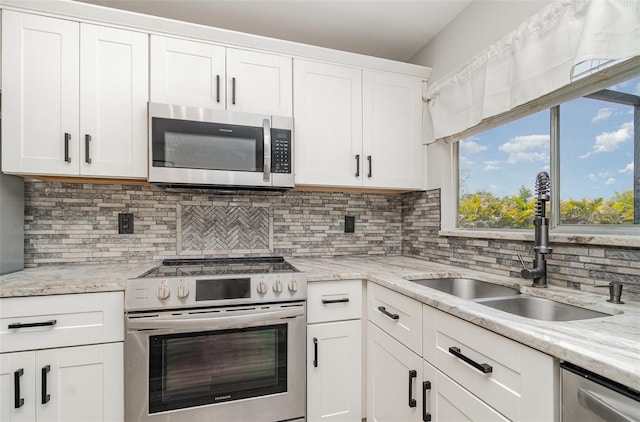 4282 Pocatella Ave, North Port, FL 34287 - kitchen featuring stainless steel appliances, a sink, decorative backsplash, white cabinets, and light stone countertops