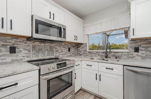 4282 Pocatella Ave, North Port, FL 34287 - kitchen featuring appliances with stainless steel finishes, a sink, white cabinetry, and decorative backsplash