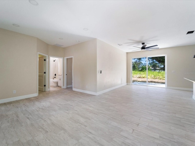 spare room featuring a ceiling fan, light wood-style floors, and baseboards