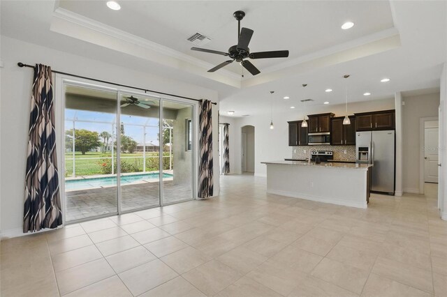 7505 Carissa, Punta Gorda, FL 33955 - unfurnished living room with a tray ceiling, ceiling fan, recessed lighting, arched walkways, and crown molding