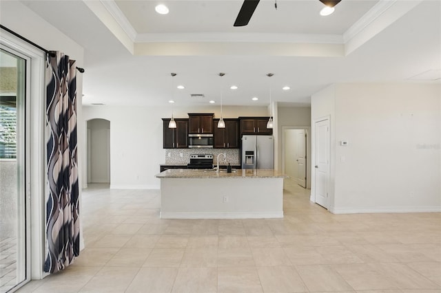 7505 Carissa, Punta Gorda, FL 33955 - kitchen with stainless steel appliances, a tray ceiling, a ceiling fan, arched walkways, and an island with sink