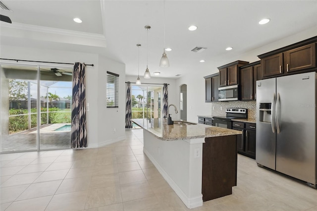 7505 Carissa, Punta Gorda, FL 33955 - kitchen with stainless steel appliances, a sink, arched walkways, a center island with sink, and backsplash