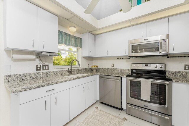 279 Mariner Ln, Rotonda West, FL 33947 - kitchen with appliances with stainless steel finishes, a sink, white cabinets, and light stone counters
