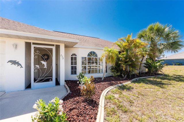 279 Mariner Ln, Rotonda West, FL 33947 - view of exterior entry featuring stucco siding and roof with shingles