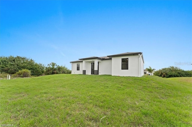 731 Colyer St E, Lehigh Acres, FL 33974 - back of house with a yard and stucco siding
