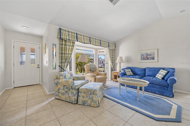 tiled living room with healthy amount of natural light, baseboards, and vaulted ceiling