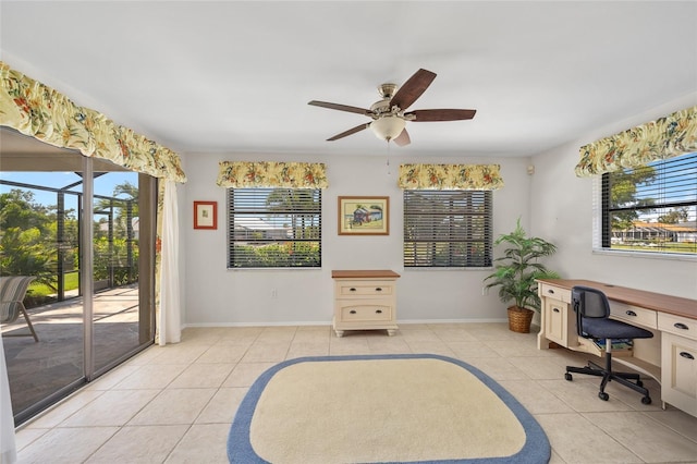 office area with light tile patterned flooring, a ceiling fan, and baseboards