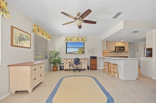 office area featuring light tile patterned floors, ceiling fan, and baseboards