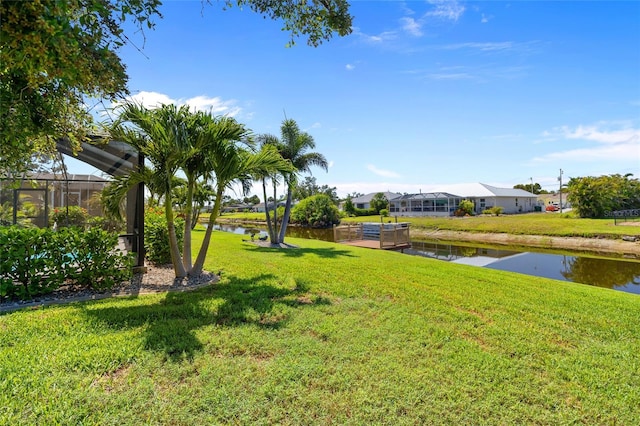 view of green lawn with a water view