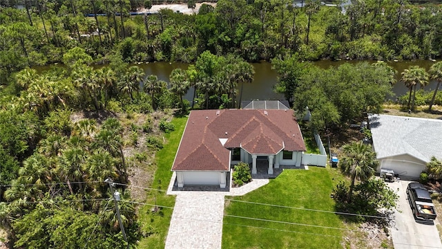 aerial view of property and surrounding area featuring a nearby body of water and a tree filled landscape